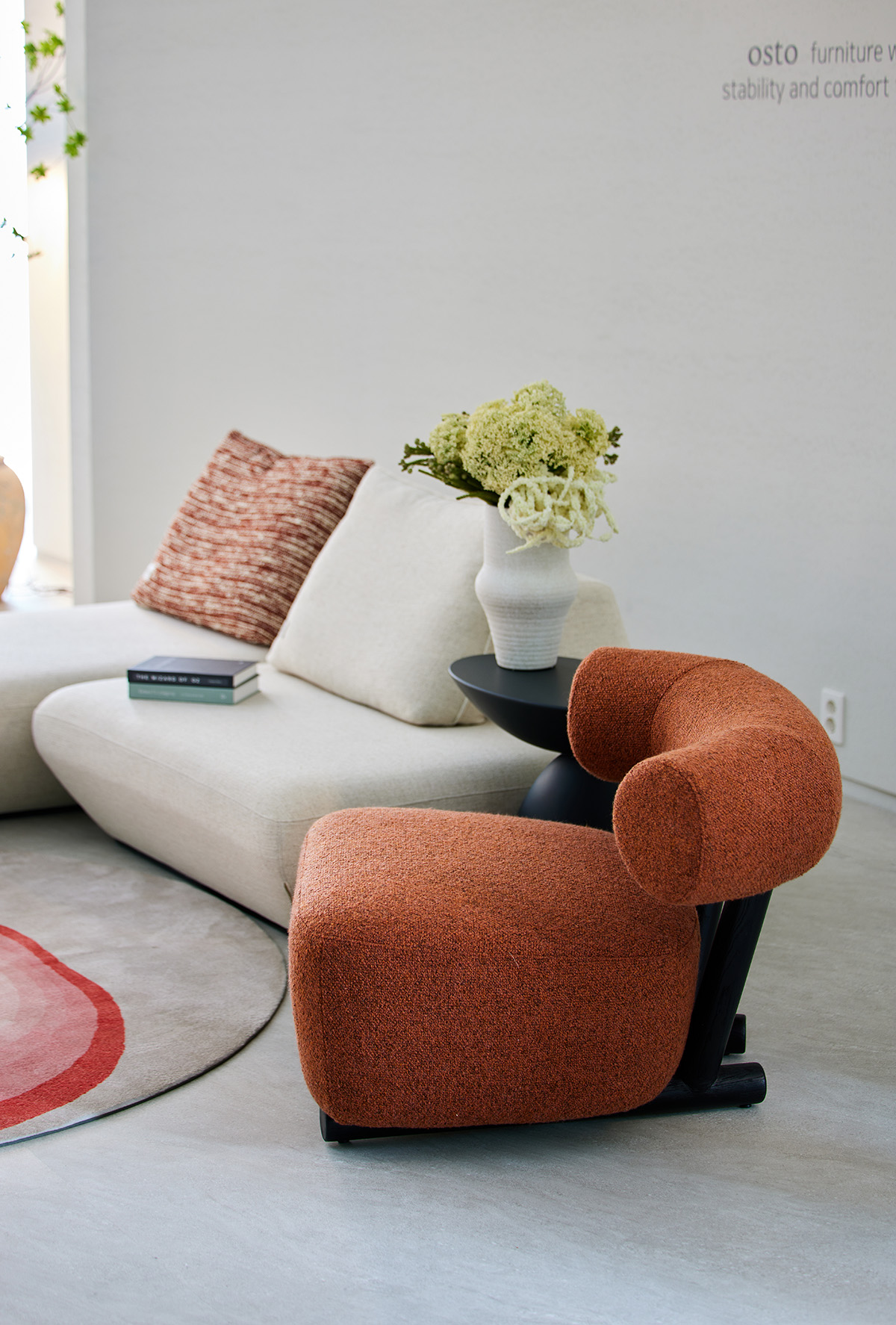 부드럽게 뻗은 원통형 등받이와 쿠션이 조화로운 체어